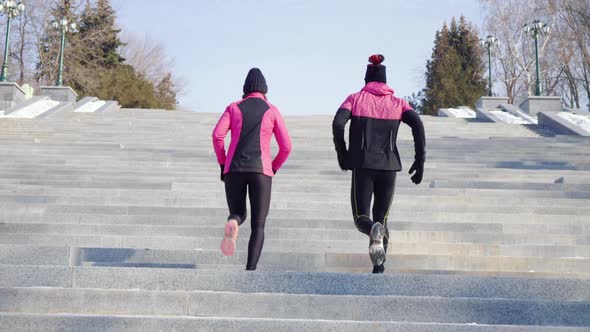 Athletic Couple Running Up Staircase in Park