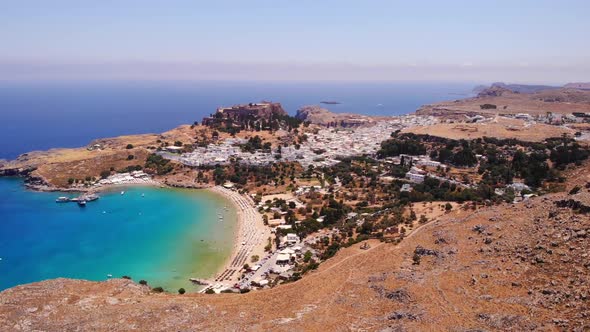 Idyllic Landscape With Beach And Castle At Lindos Village, Rhodes, Greece - aerial drone shot