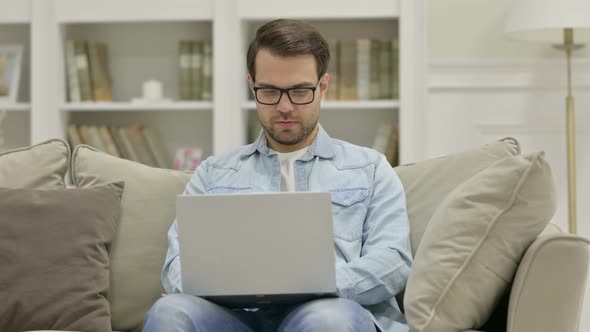 Focused Young Man Working on Laptop at Home