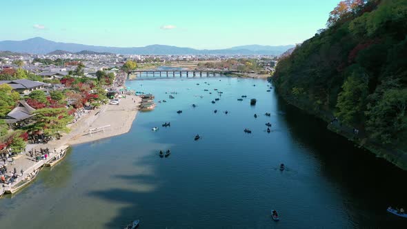 Aerial view 4k by drone of Katsura river at autumn and boats. Arashiyama, Kyoto