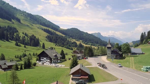 Aerial View of a Valley in Switzerland with Chalets and a Mountainous Landscape