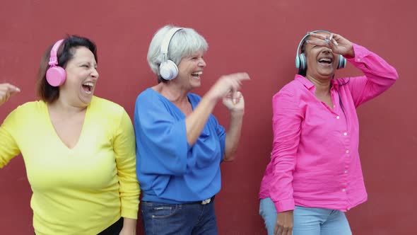 Happy Multiracial Senior People Listen Music and Dance Wearing Headphones Older Friends Community