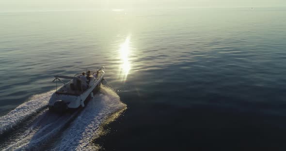 A Drone Shot of a Happy Family on a Summer Vacation Driving a Luxury Boat on the High Seas in the