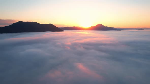 4K Aerial view flying in fog. the sun is hidden behind the clouds at sunset fog.