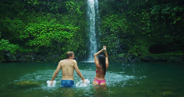 Couple Relaxing Under Waterfall