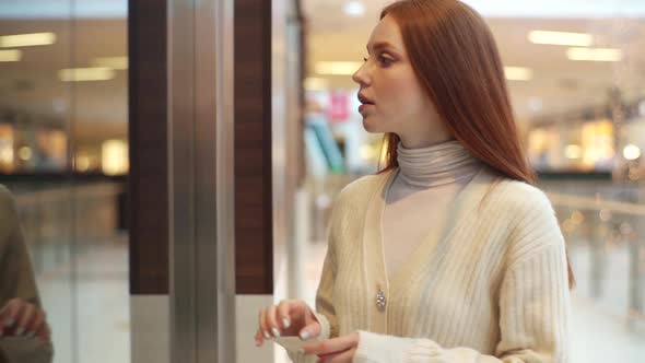 Happy Excited Young Woman Walking at Shopping Mall Passage and Stop at Shop Showcase Attracted By