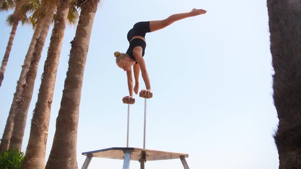 Gymnastics By the Sea a Young Blonde Woman Doing a Handstand on the High Small Beams in Gymnastic