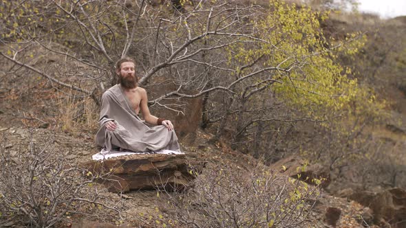 Buddhist Meditates on the Rock