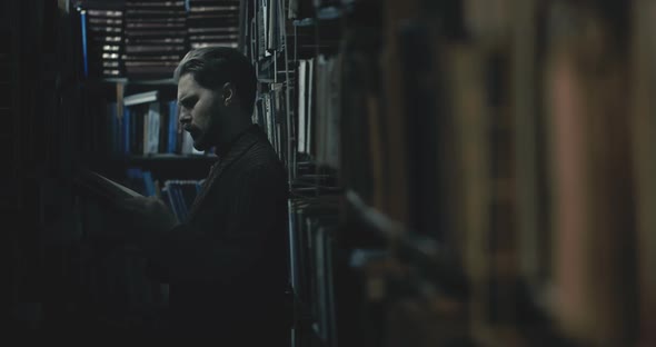 Man Choosing Book in Dark Library