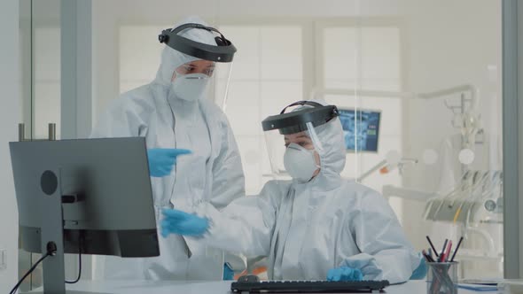 Dentistry Team of Specialists with Ppe Suits Using Computer