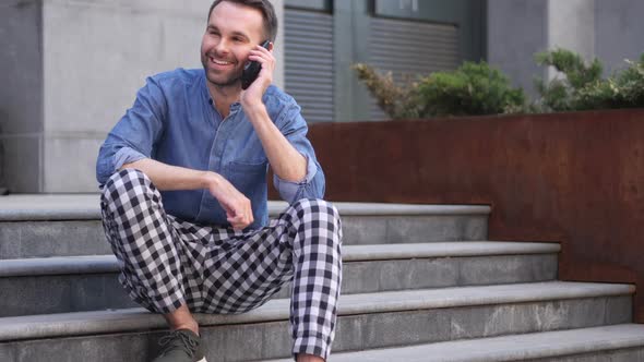 Phone Talk Man Attending Call While Sitting on Stairs Outside Building