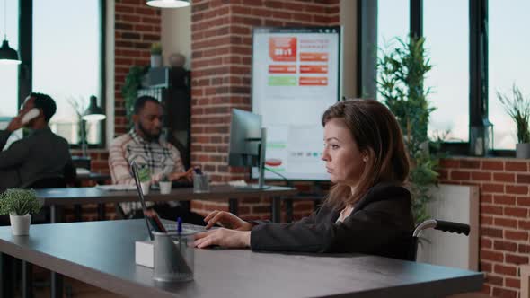 Portrait of Female Employee Analyzing Statistics on Laptop