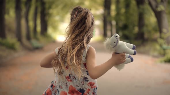 Girl Running Away Parents. Active Young Children Enjoy Playing Funny Activity Together With Father.