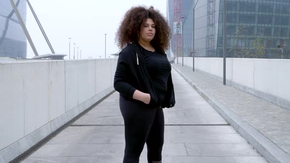 Plus size sportive young woman posing in the city