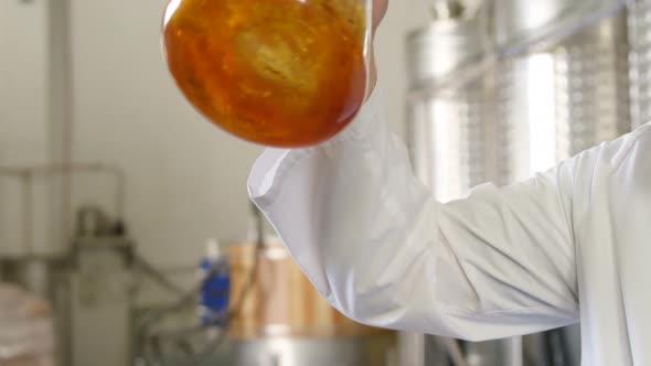 Male worker examining liquor in flask 4k