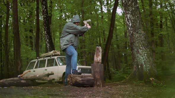 Slow Motion Of Casual Strong Man Works with Ax in Wild Deciduous Forest and Vintage Classic Car in