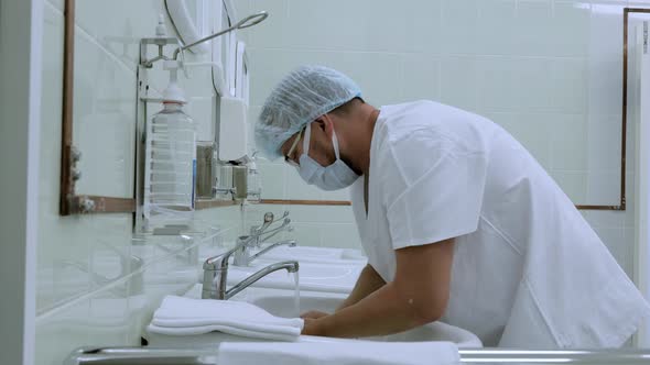 Doctor surgeon preparing for surgery and washes his hands