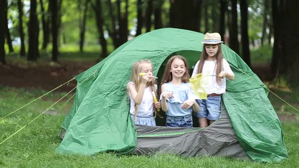Adorable little siblings in a tent in a park outdoors.