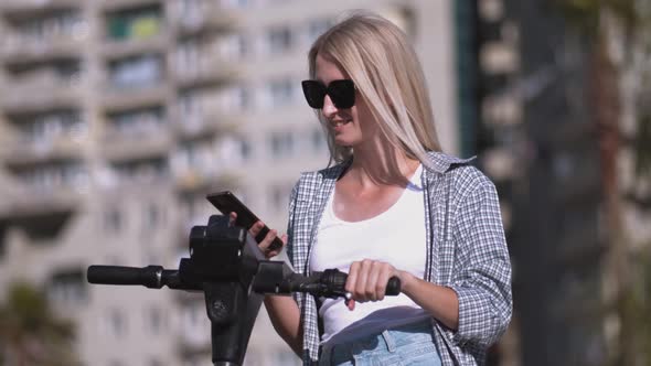 Woman unlocks electric scooter app with her smartphone.