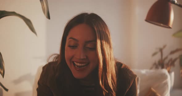 Woman smiles while on video call on laptop