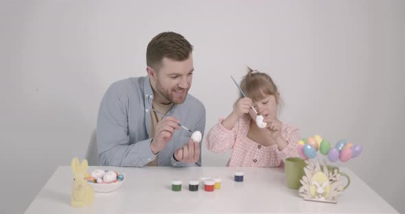 Girl with Down Syndrome Painting Easter Eggs with Father
