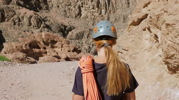 Rock Climber in a Helmet Goes Along a Canyon