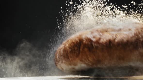 Fresh Rye Bread with White Flour Falls Down on Table Macro