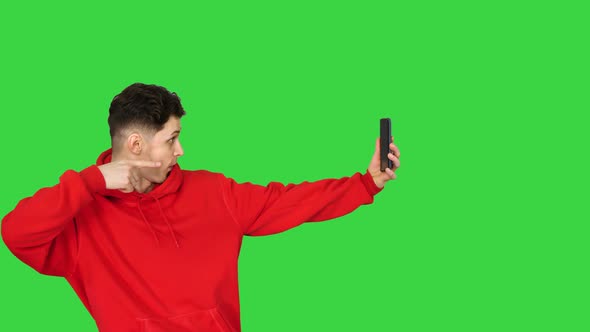 Excited Casual Man Dancing and Making Selfie with His Phone on a Green Screen, Chroma Key.