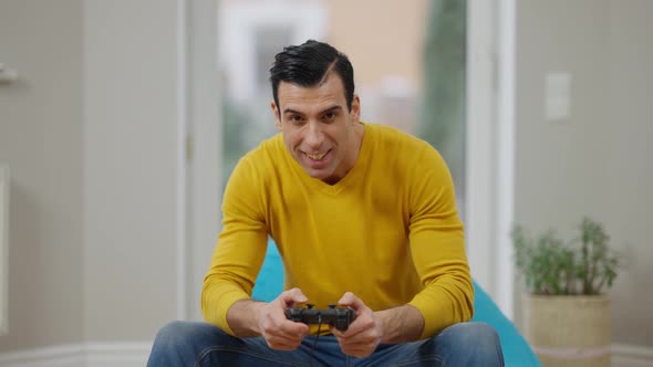 Portrait of Happy Carefree Middle Eastern Man Using Game Console Winning in Video Game