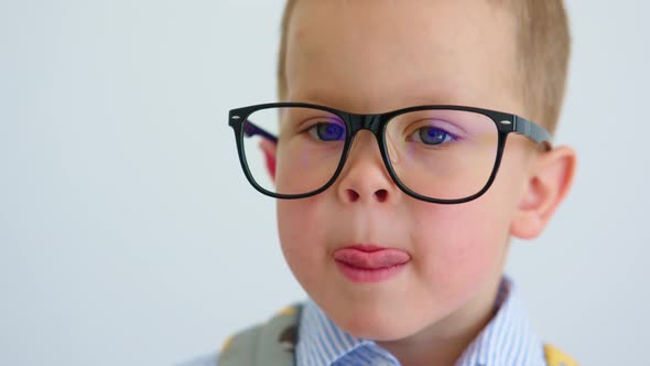 Portrait of Funny Serious Baby Child Boy in Glasses Making Face Grimacing Camera