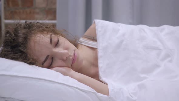 Beautiful Young Female Sleeping in Bed at Night