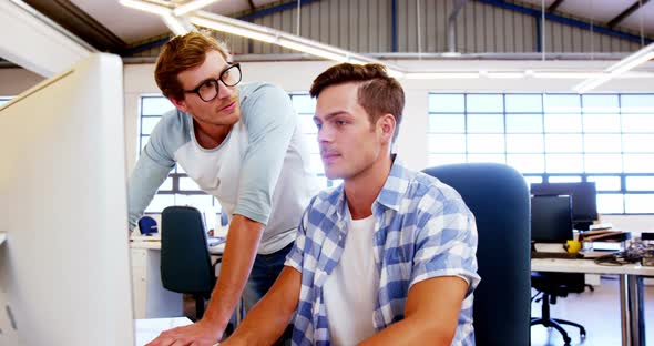 Colleagues looking at computer and discussing with each other