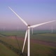 Windmills with rotating wings among green fields. Wind farm for wind energy. - VideoHive Item for Sale