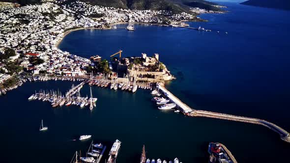 View from drone on full of yachts Bodrum harbour and ancient Kalesi castle in Mugla in Turkey