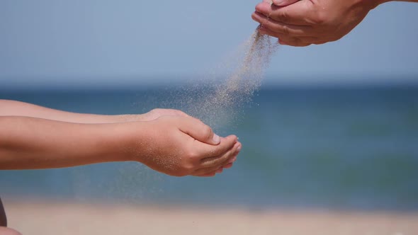 Rest on the Sea with Children. Sand Is Poured From the Palms of the Hands Into the Palms