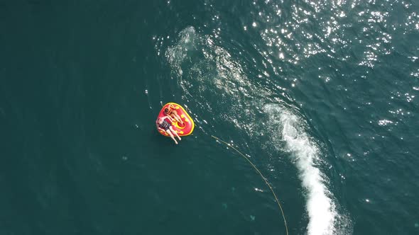 Happy People are Going to Swim on an Air Mattress Behind a Jet Ski