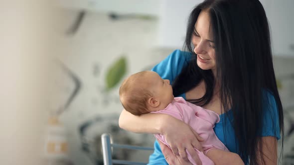 Young Mother Embracing Her Newborn Baby