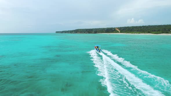 Motorboat sails in turquoise caribbean waters. Bahia de las Aguilas