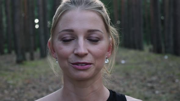 Portrait of Young Blond Caucasian Woman with Ponytail at Forest Closeup