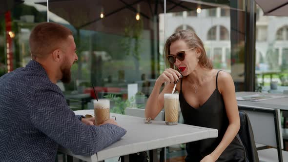 Sexy Young Woman is Flirting in Cafe with Handsome Man Drinking Latte and Laughing