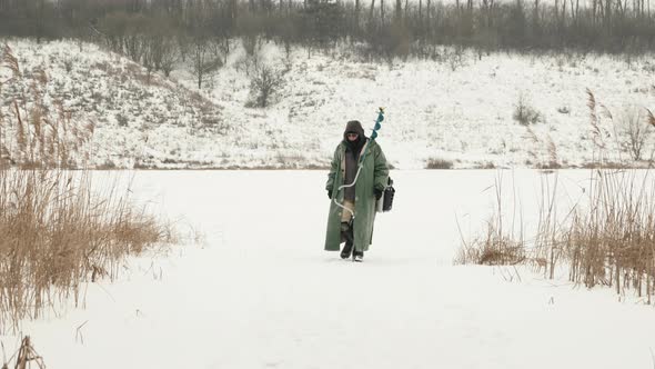 Winter fishing. Fisherman is going from winter fishing