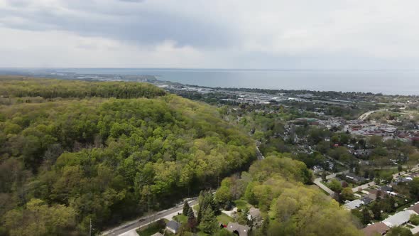 Beautiful aerial flight over natural forest near Grimsby City and Lake Ontario in background. Hamilt