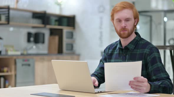 Beard Redhead Man with Laptop Working on Documents 