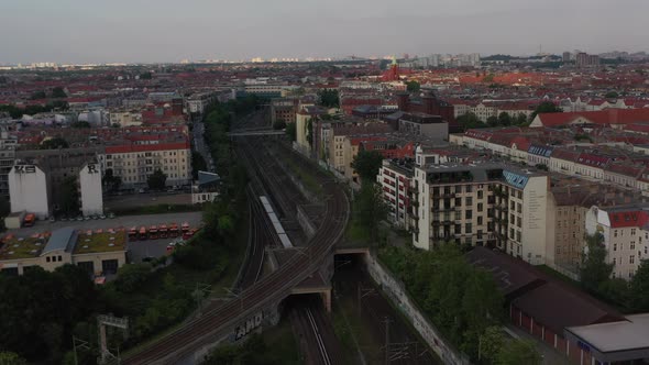 Aerial View of Regional Train Driving on Railway Tracks Between Residential Tenement Houses in City