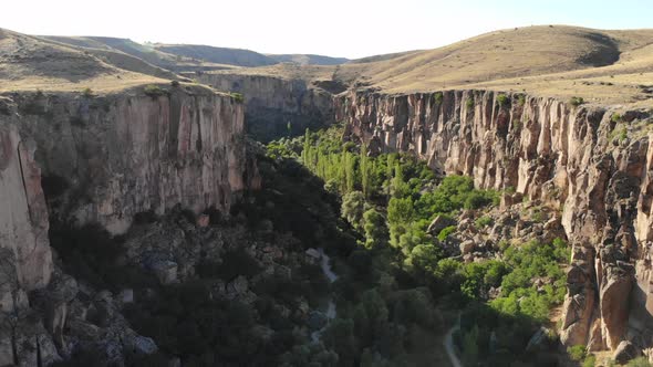 Aerial Deep Long Rift Canyon with Cleft Steep Rock Walls and High Cliff Gorge