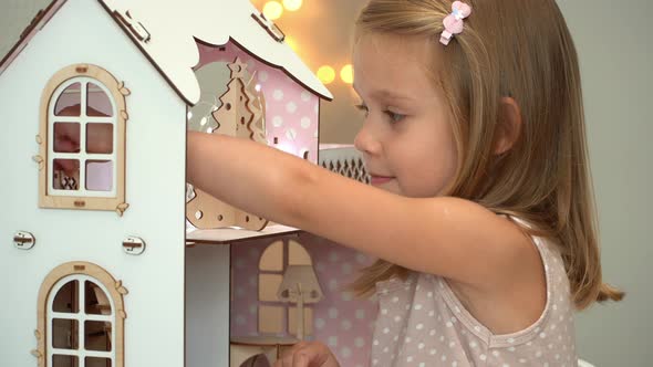 Girl Plays with Dollhouse