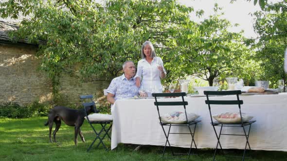 WS, Family in garden together around table for dinner
