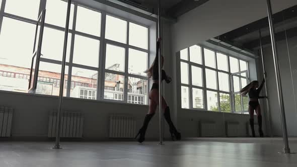 Flexible Woman Dancing on Pole in Studio