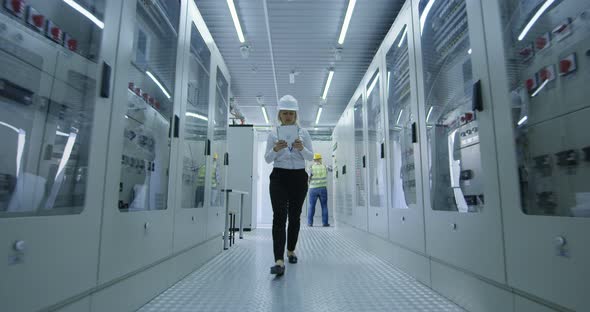 Female Electrical Worker Walking Down the Hall