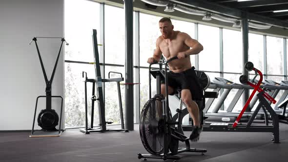 Man Exercise Bike Gym Cycling Training Fitness. Fitness Male Using Air Bike Cardio Workout. 